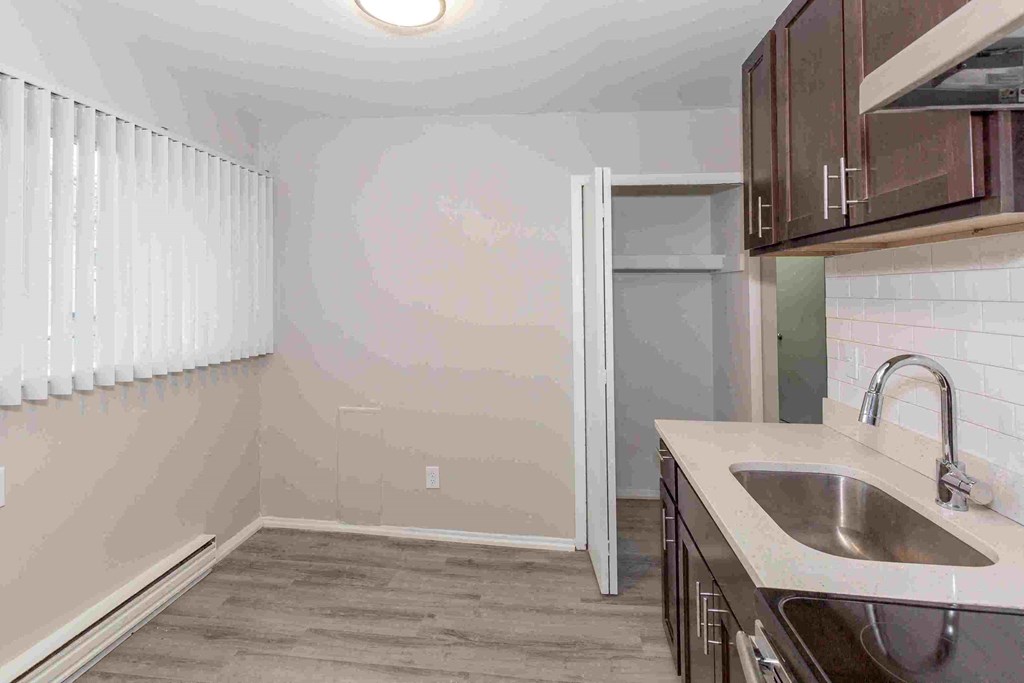 an empty kitchen with a sink and counter top