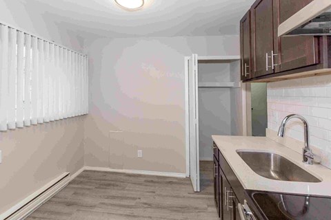 an empty kitchen with a sink and counter top