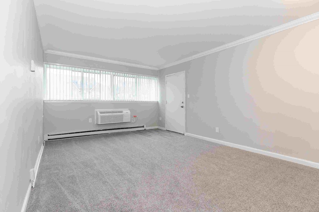 an empty room with white walls and a window