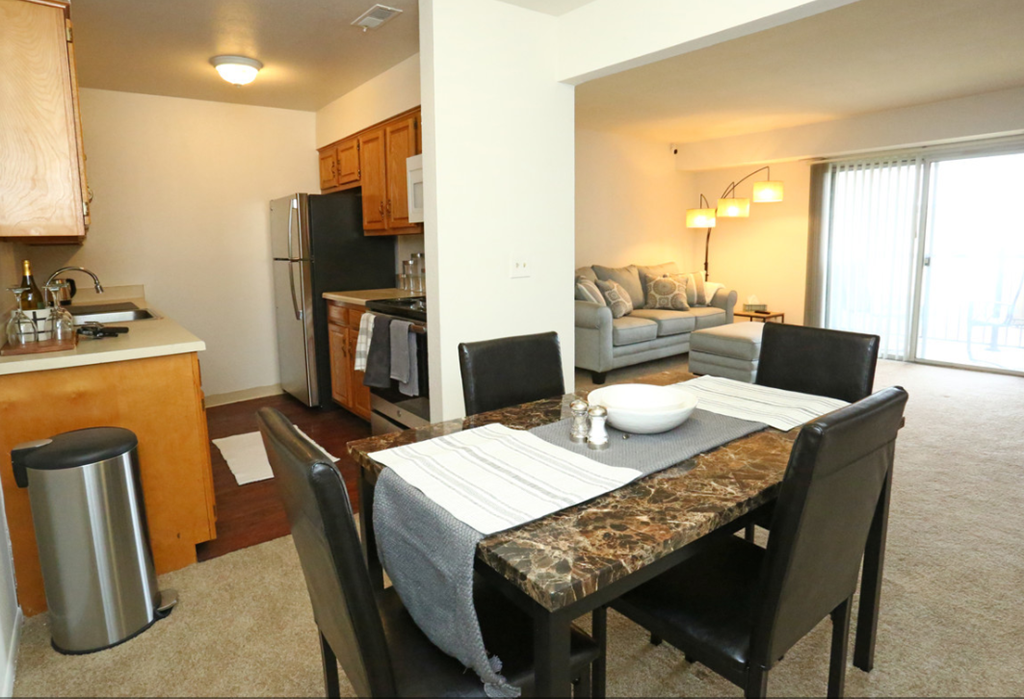 a dining room and living room with a table and chairs