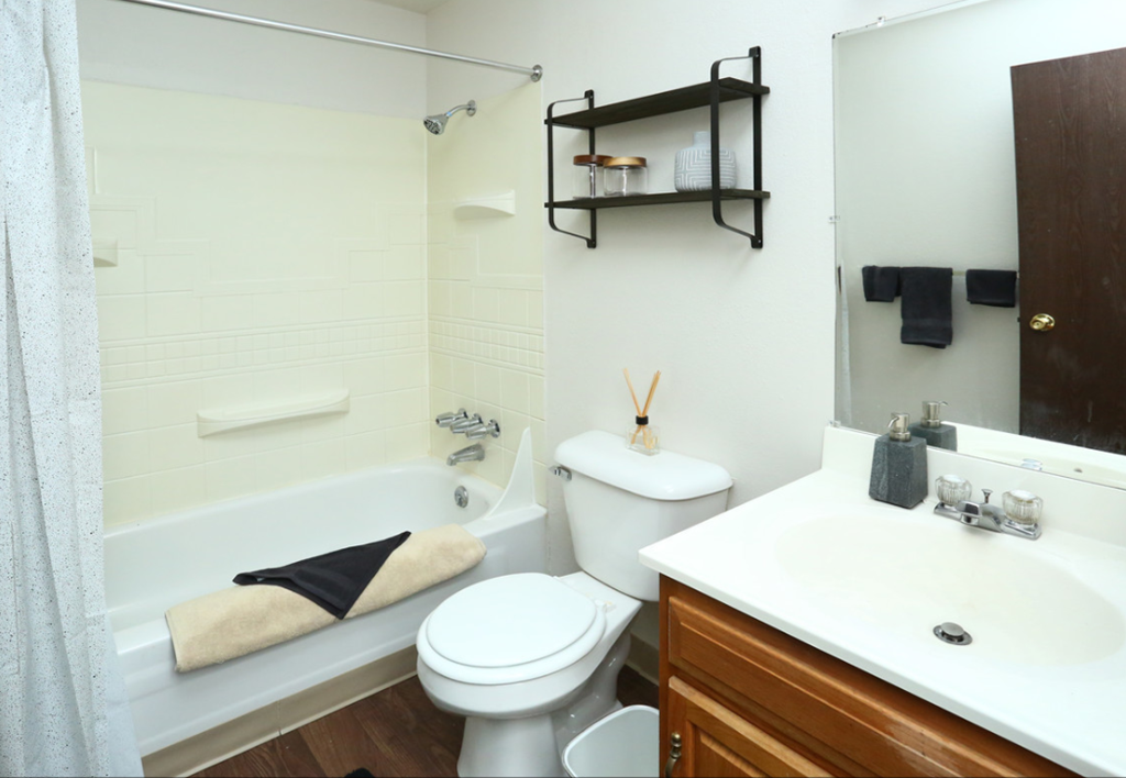 a bathroom with a toilet sink and tub and a mirror