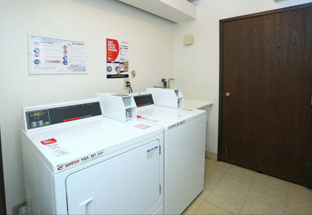 a laundry room with two washers and two washing machines