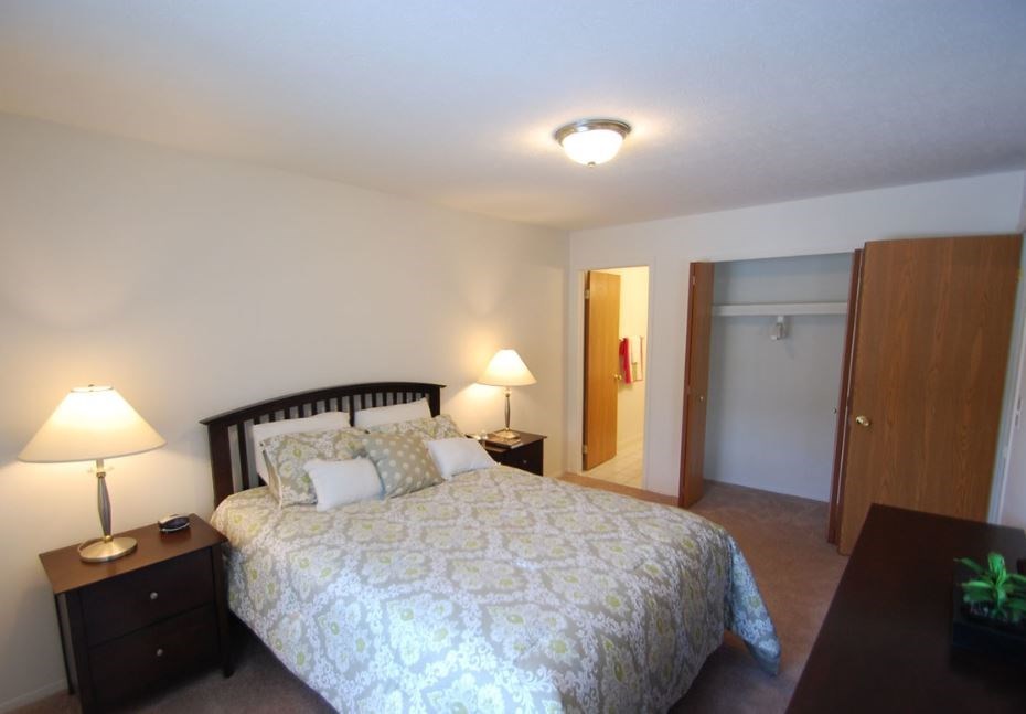 a bedroom with a bed and a door to a bathroom