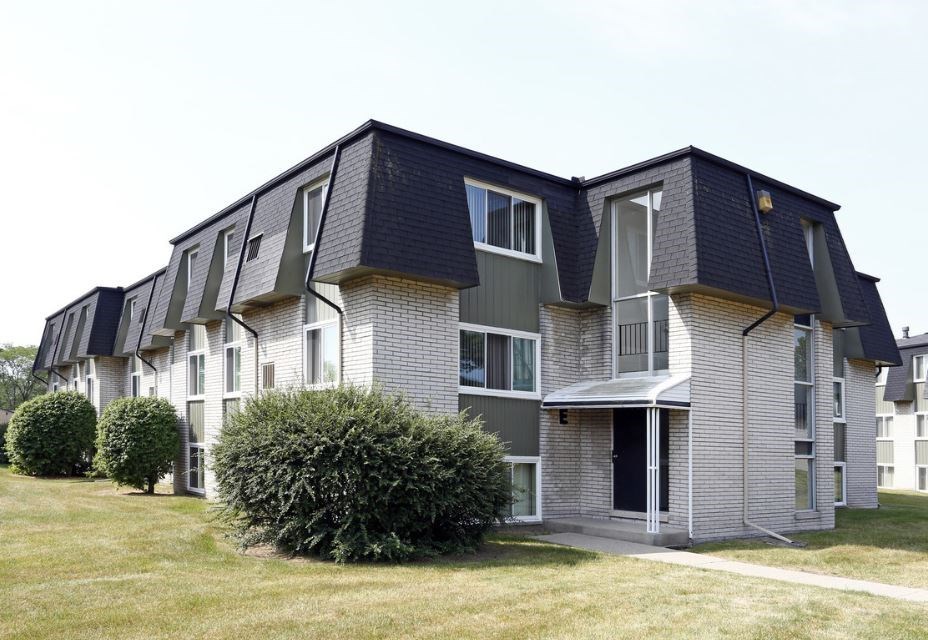 an apartment building with a yard in front of it