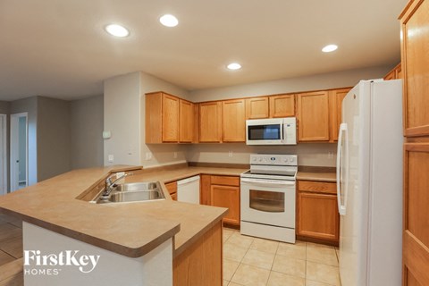 A kitchen with wooden cabinets and a white refrigerator.