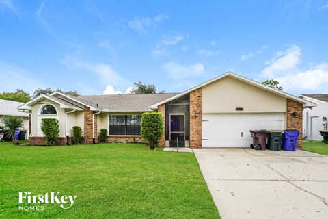 A house with a garage and a driveway in front of it.