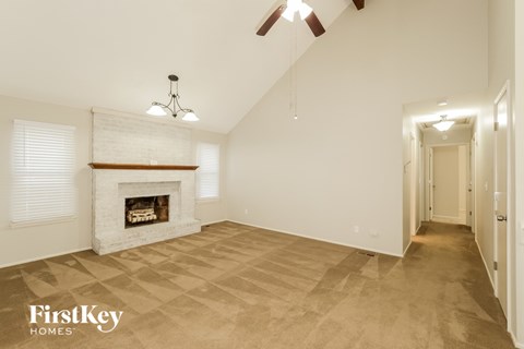 a living room with a fireplace and a ceiling fan
