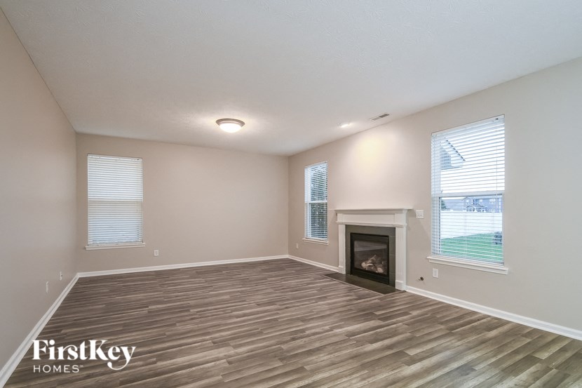 the living room with wood flooring and a fireplace