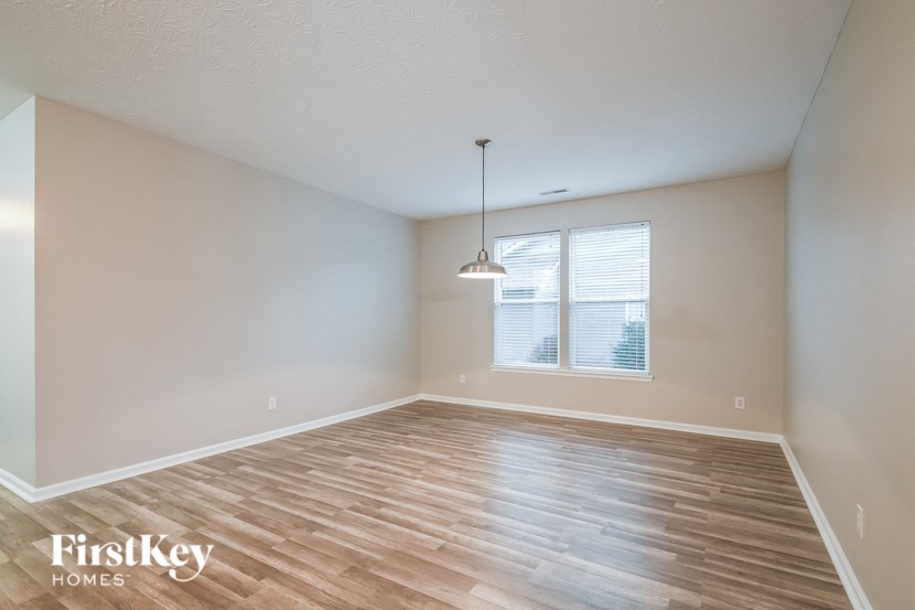 the spacious living room with wood flooring and a large window