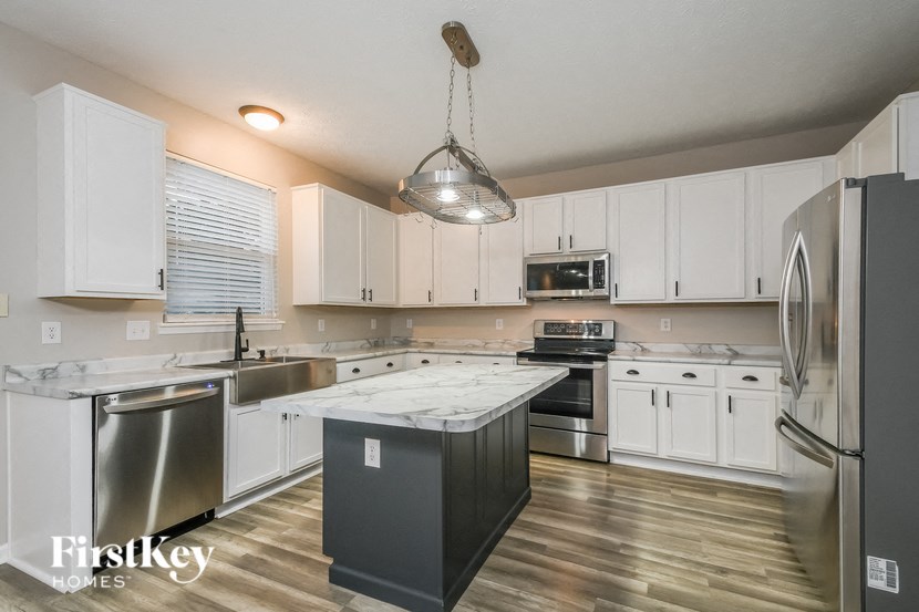 a kitchen with white cabinets and stainless steel appliances