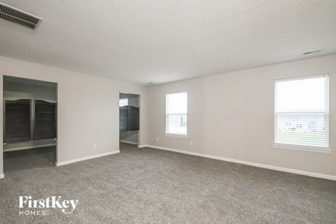 the living room of an apartment with carpet and a closet