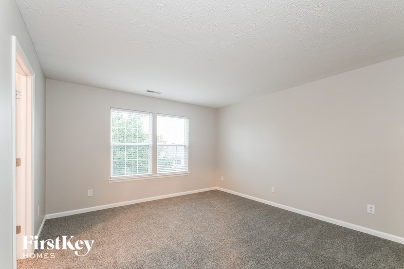 a bedroom with a carpeted floor and a window
