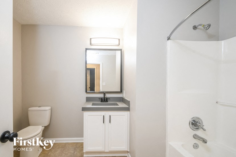 a bathroom with a toilet sink and shower and a mirror