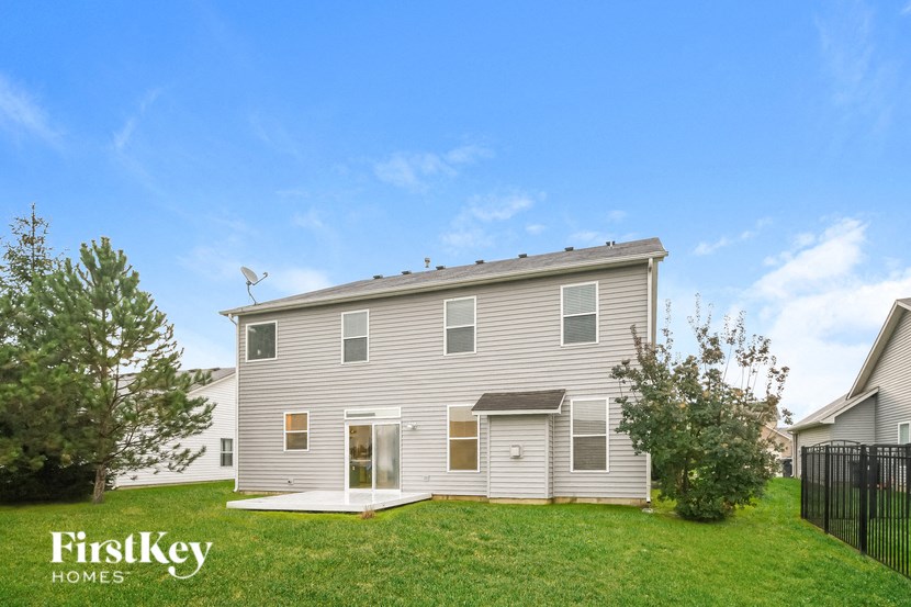 a with a green lawn and a black fence