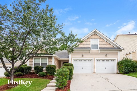 A house with a tree in front and the words "FirstKey Homes" on the lawn.