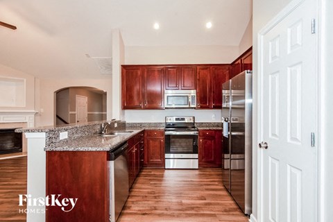 A kitchen with wooden cabinets and a granite countertop.