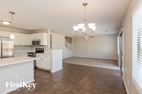 A kitchen with white cabinets and a tiled floor.