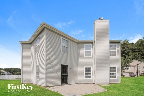 a white house with a ramp in front of a grass field