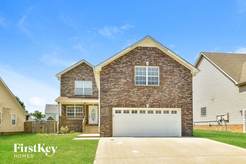 a brick house with a white garage door and a lawn