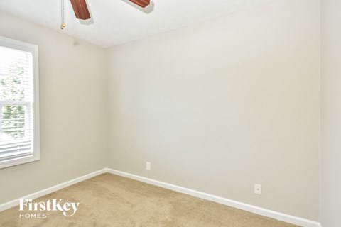 a bedroom with a carpeted floor and a window