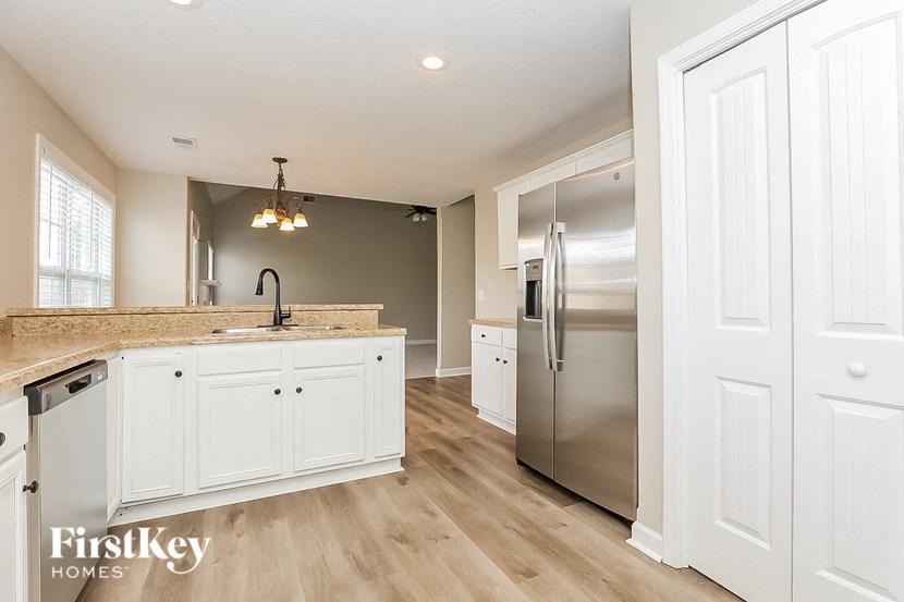 a kitchen with white cabinets and a stainless steel refrigerator