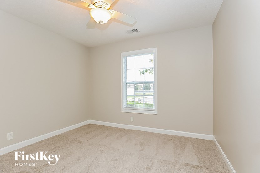 a bedroom with a ceiling fan and a window