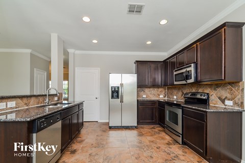 a kitchen with dark wood cabinets and stainless steel appliances