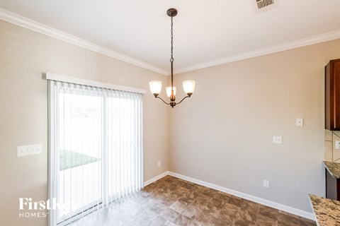 a dining room with a large window and a chandelier