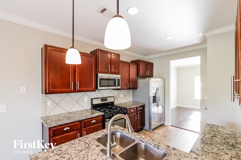 a kitchen with wooden cabinets and stainless steel appliances and granite counter tops