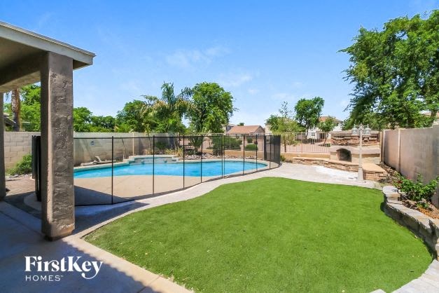 A backyard with a pool and a fence.