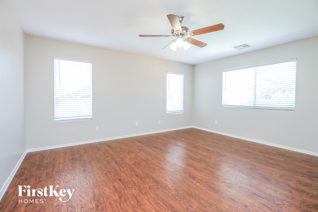A room with wooden flooring and a ceiling fan.