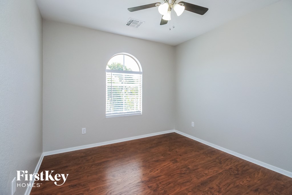 A room with a wooden floor and a ceiling fan.
