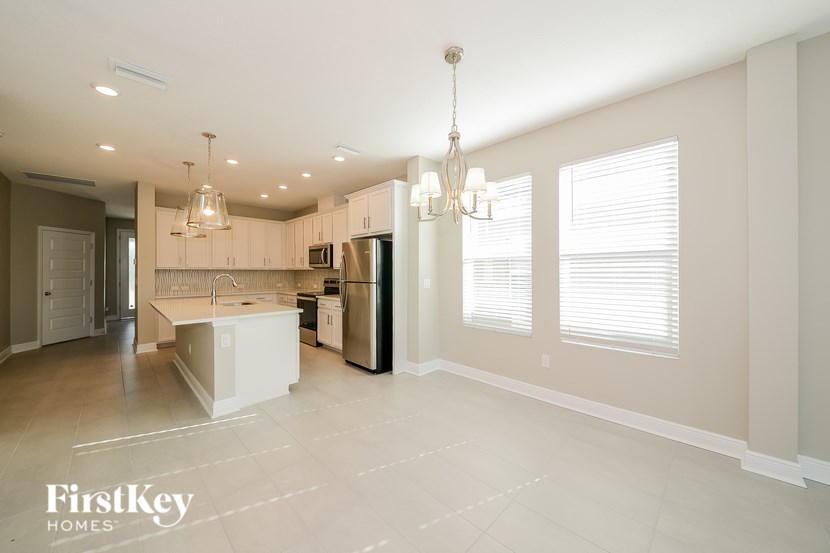 A spacious kitchen with a refrigerator, sink, and cabinets.