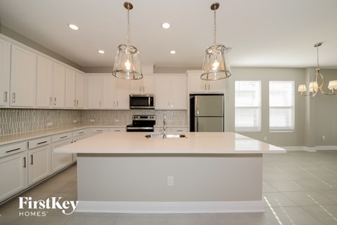 A kitchen with a white counter top and cabinets.