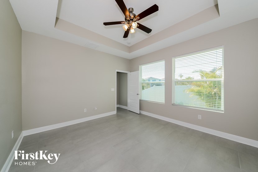A spacious room with a ceiling fan and sliding glass doors.
