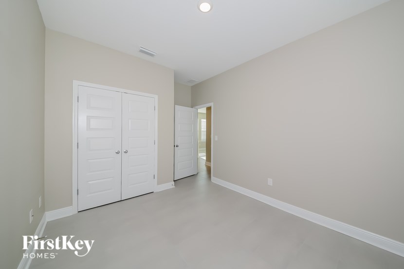 A spacious room with a white door and a FirstKey Homes logo.