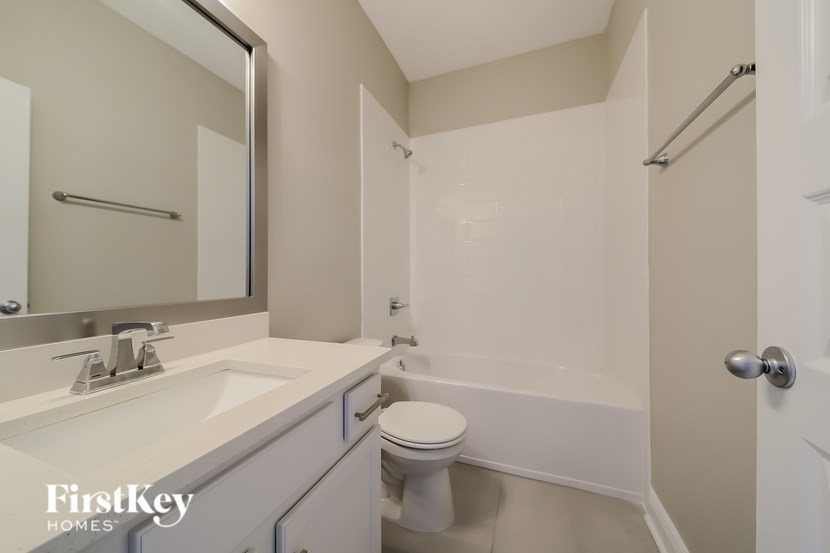 A white bathroom with a toilet, sink, and bathtub.