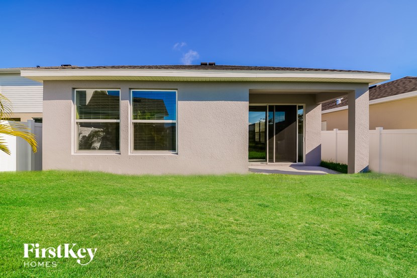 A house with a green lawn and a blue sky in the background.