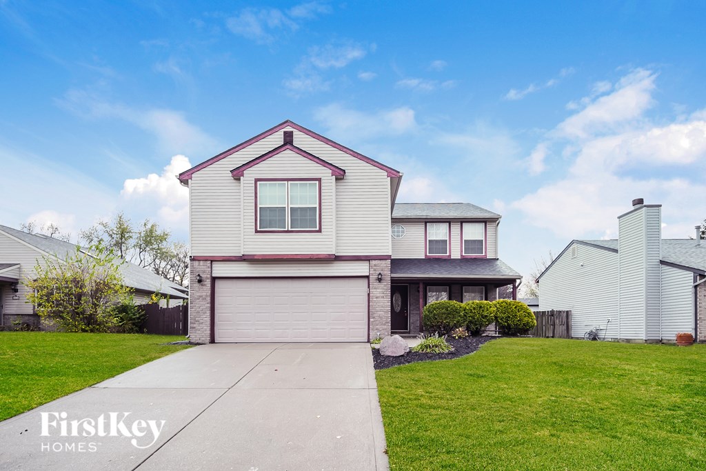 A house with a red roof and a garage door is for sale.