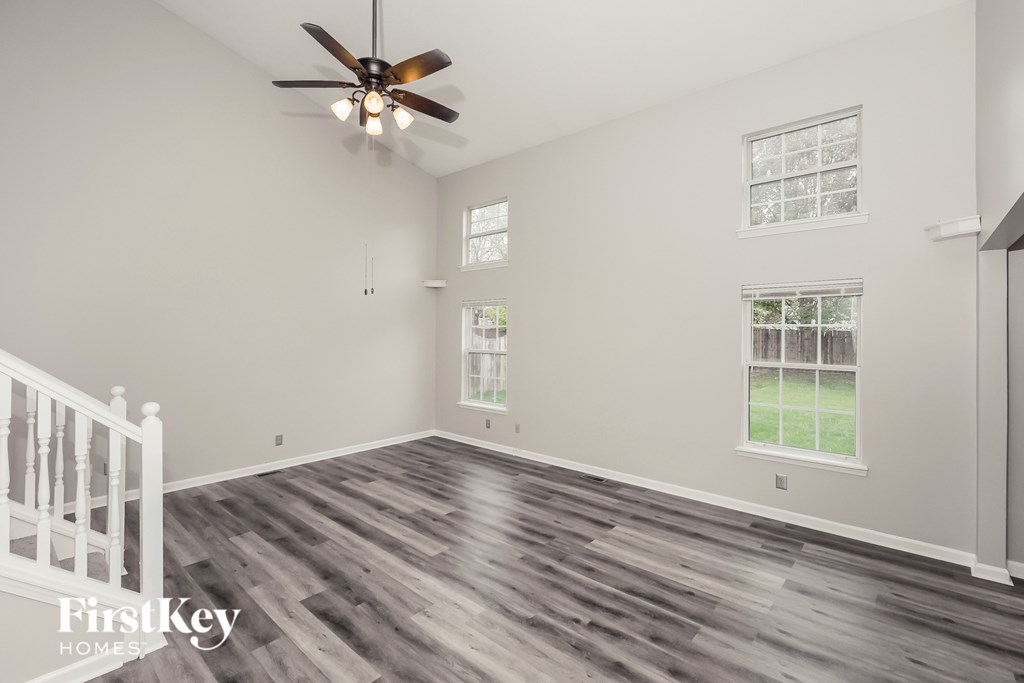 A room with a ceiling fan and wooden flooring.