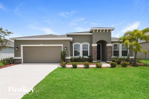 A house with a garage and a driveway in front of it.