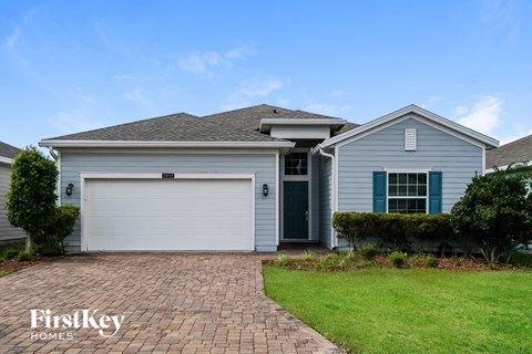 a blue house with a garage door and a green lawn