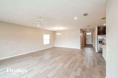 the living room is spacious with hardwood floors and a kitchen