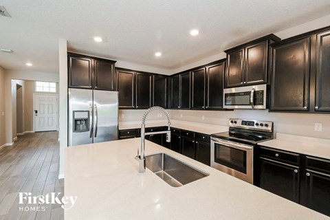 a kitchen with black cabinets and white counter tops and a sink