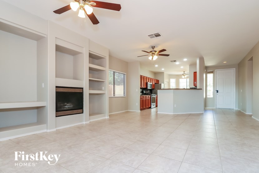 A spacious living room with a fireplace and built-in shelves.