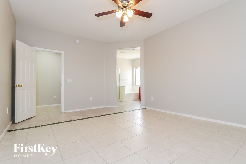 A spacious room with a ceiling fan and tiled flooring.