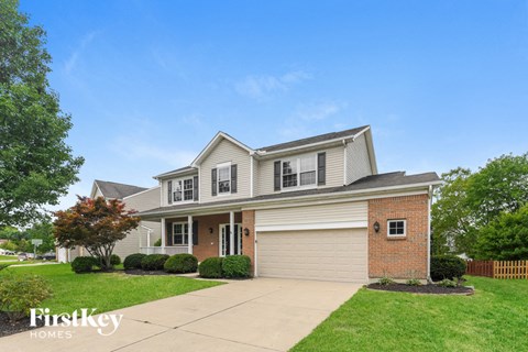 a house with a lawn and a sidewalk in front of it