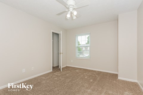 a bedroom with carpet and a ceiling fan