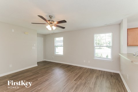 a living room with hardwood floors and a ceiling fan