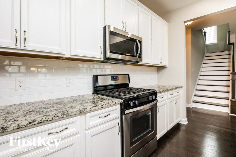 A kitchen with white cabinets and a granite countertop.